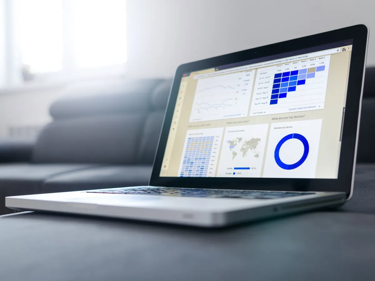 Laptop showing charts and graphs on its screen in a bright room